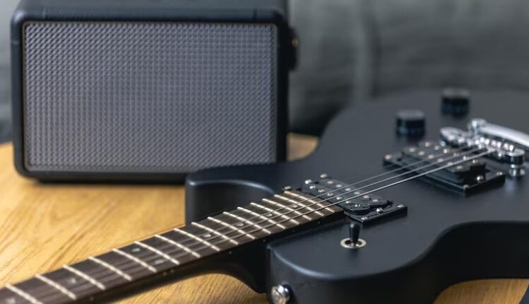 Close-up of a compact guitar amplifier and electronic guitar representing the Quad Cortex Mini setup